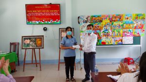 thầy Lưu phước Quang  - Hiệu  trưởng nhà trường trao quỹ vận động chia sẻ yêu  thương (2.000.000 đồng) cho em Nguyễn Thị Kim Ngân - lớp 9A1